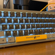 A photo of the Shurikey Hanzo Retro Computer model keyboard, with gray frame, dark gray alpha keys with white legends, and bright yellow accents.